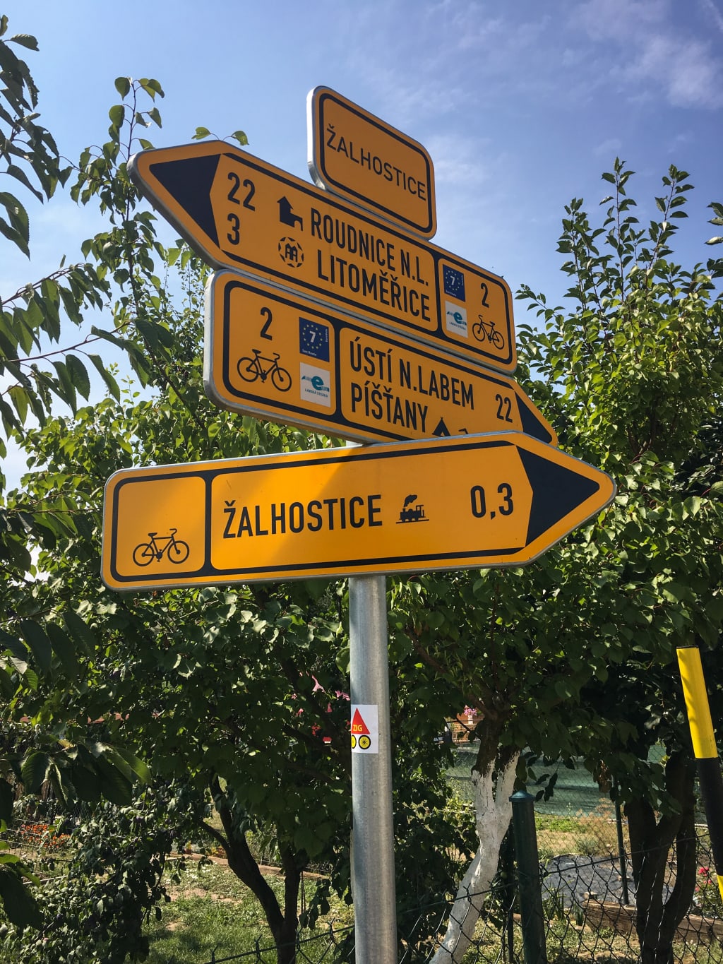 Cartelli segnaletici gialli con scritta nera indicano le direzioni lungo la Ciclabile dell'Elba e della Moldava.